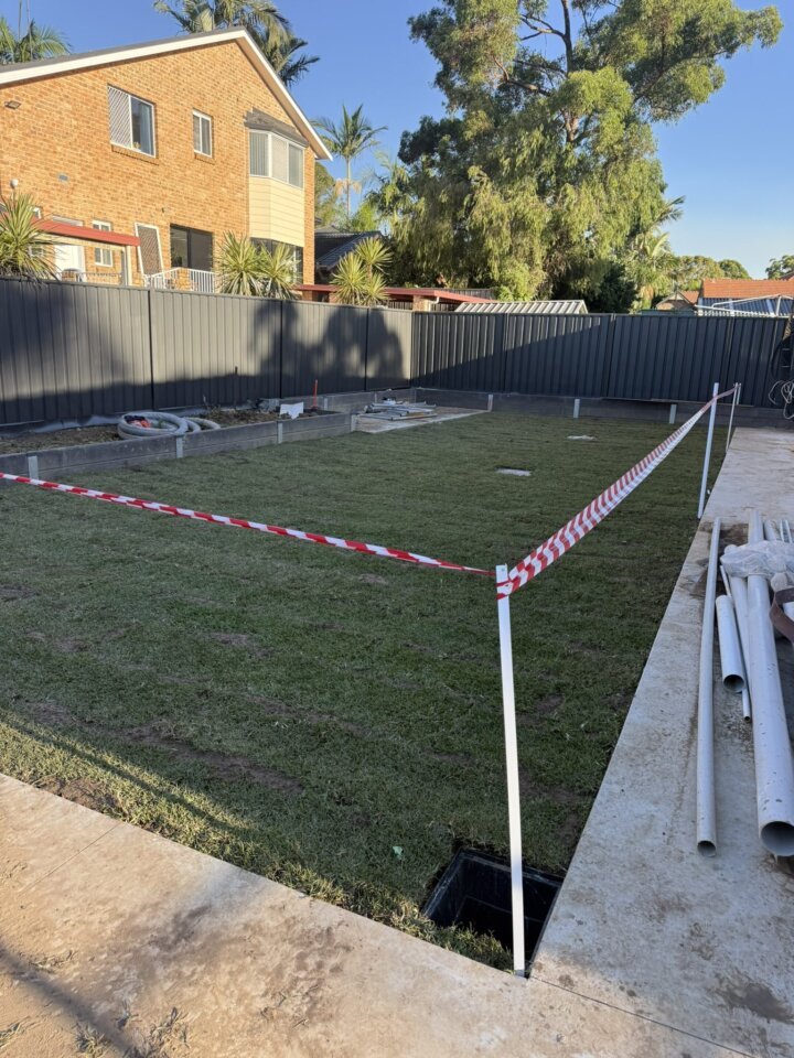 Freshly laid turf roped off to settle beside a new concrete path